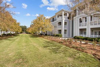 an empty lawn in front of an apartment building